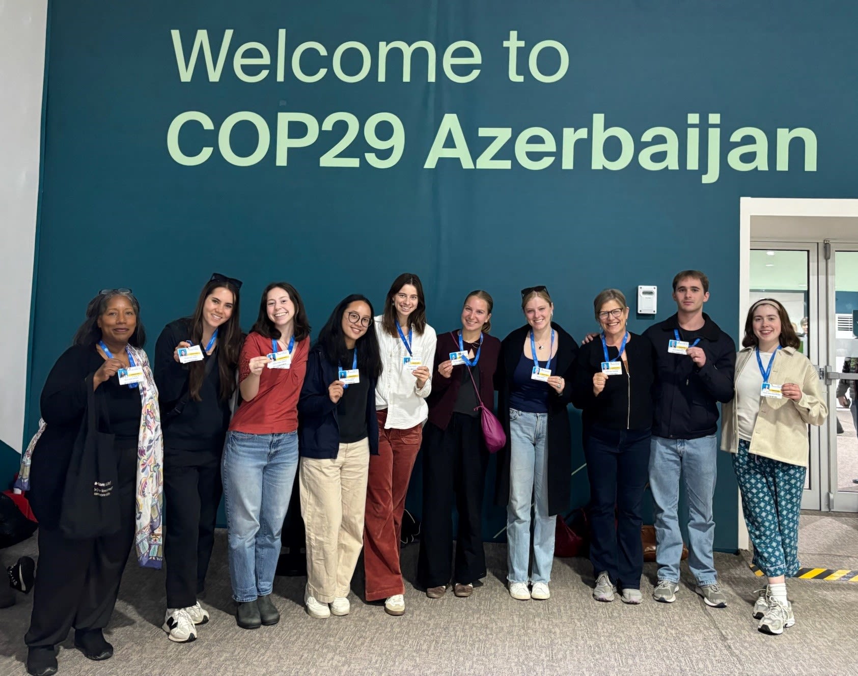 Hautzinger and Jackson are pictured with Megan O'Brien '25, Ashley Entwistle '26, Ella Reese-Clauson '26, Isabella Childs Michael '25, Jessica Legaard '25, Havalin Haskell ’26, and Jamie Harvie ’25, after receiving their official badges at the COP29 venue.