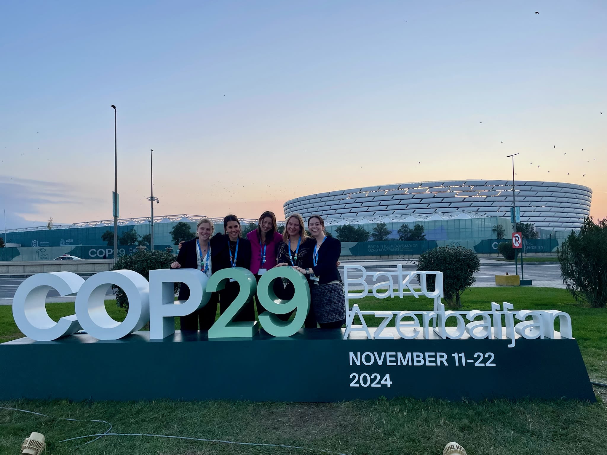 Some of CC delegates at COP29 outside the Green Zone with the stadium that held in the Blue Zone in the background.
