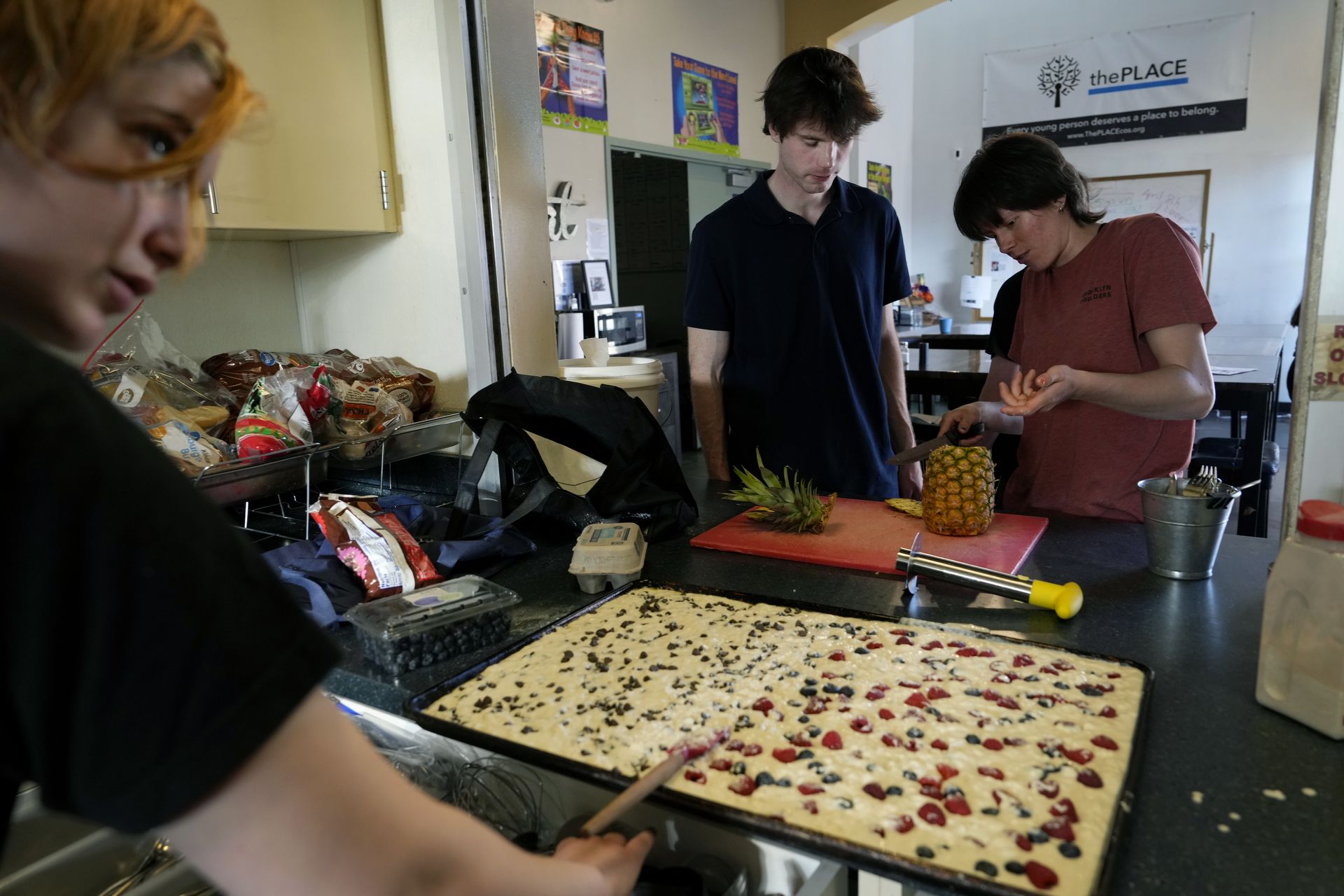 Students Raphael Sullivan, left to right, Kevin Gochee, and Melanie “Mel” Robertson make dinner and the next morning’s breakfast on April 4 at The Place for around 20 unhoused youth. The three students are members of Allies of Unhoused Youth (AUY), a student organization created last year whose members volunteer their time and services for people and places in need.