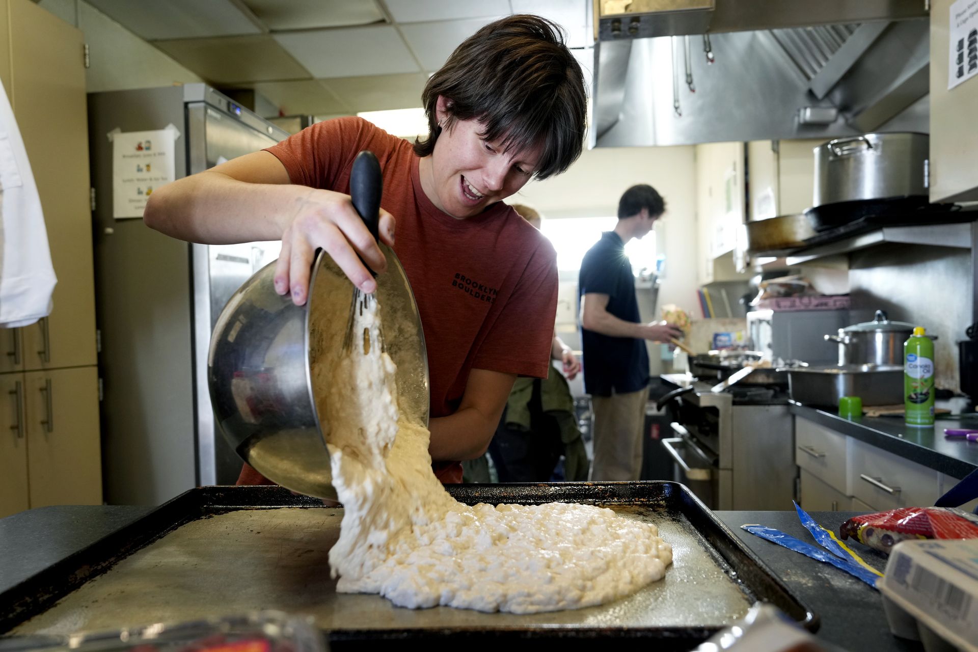 Student Melanie “Mel” Robertson helps prepare dinner and the next morning’s breakfast on April 4 at The Place, a shelter downtown for unhoused youth.