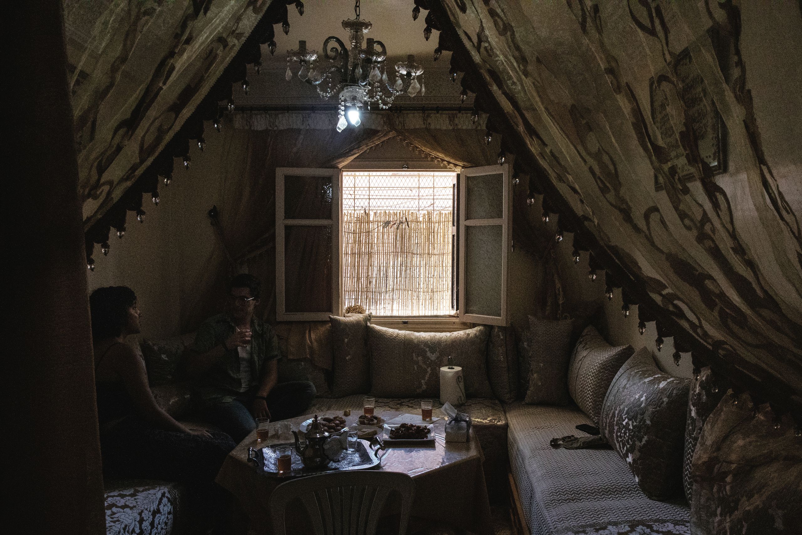 Interior of a room with intricate drapes along the walls, surrounding a seating area with a table.