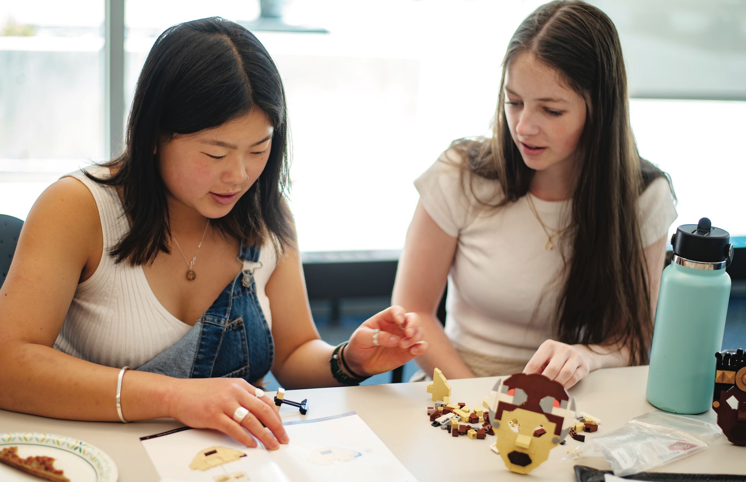 n an event hosted by the Colorado College History Department,  Rose Ryan '26 (left) and Caroline Bay '26 (right) recreate the lost Ghanaian Asante Palace with historian and graphic novelist Trevor Getz using Legos