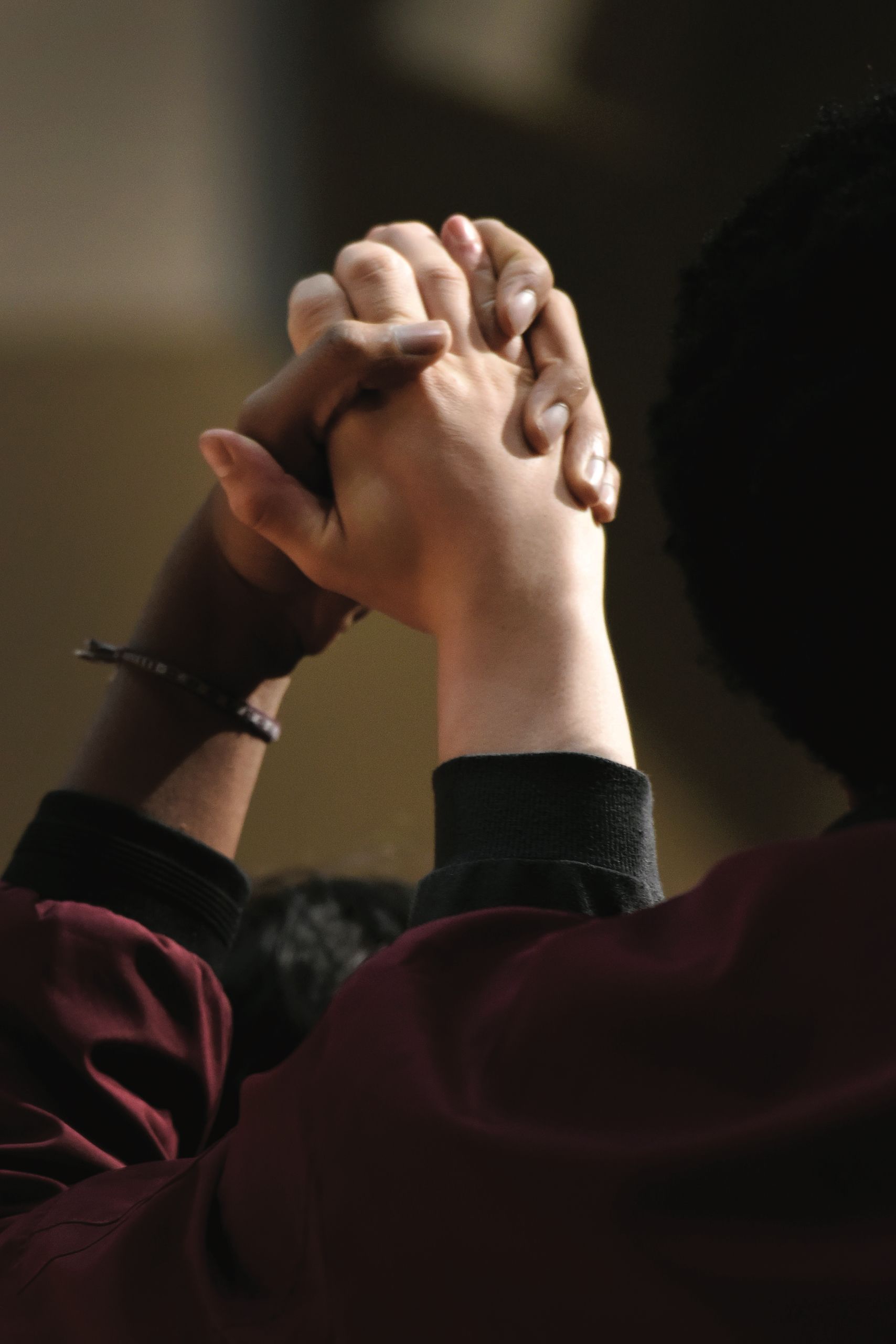 Two people clasping hands during a performance by Aisha Fukushima