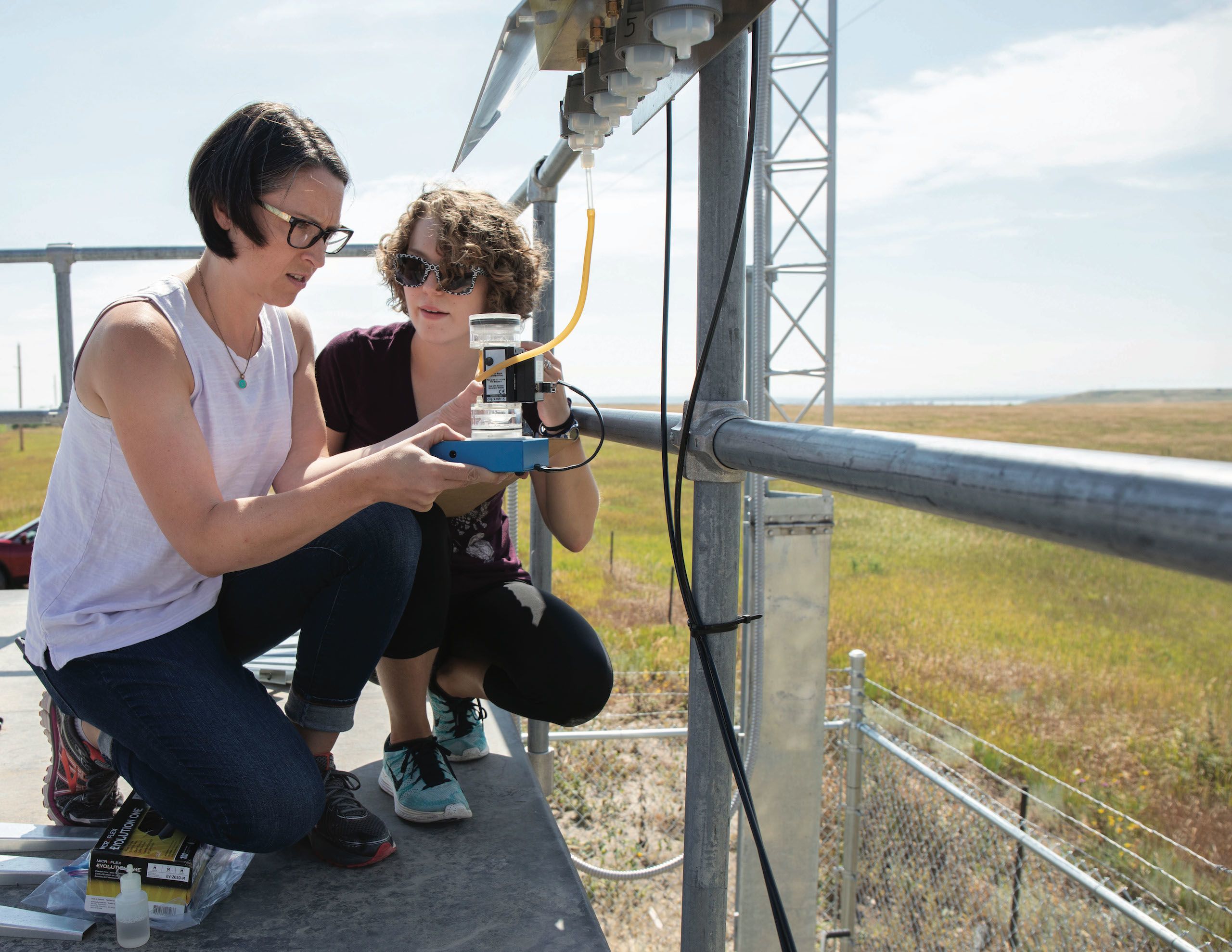 Story Schwantes ’19 and Melissa Taing ’19 working in a field with devices that calculated the amount of mercury floating down from the upper atmosphere in that area.