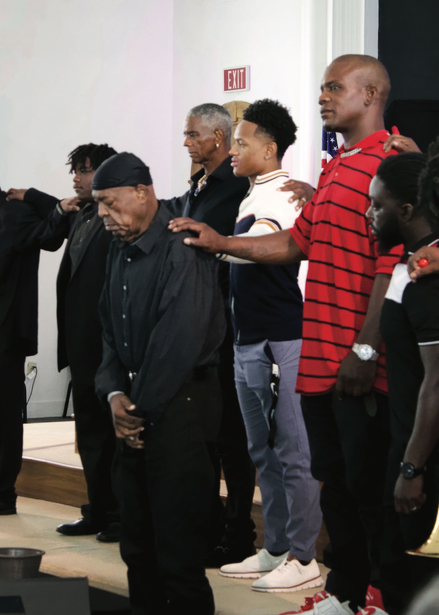 Kennedy participating in a group prayer. Kennedy grounds himself through spiritual life and community beyond the classroom.