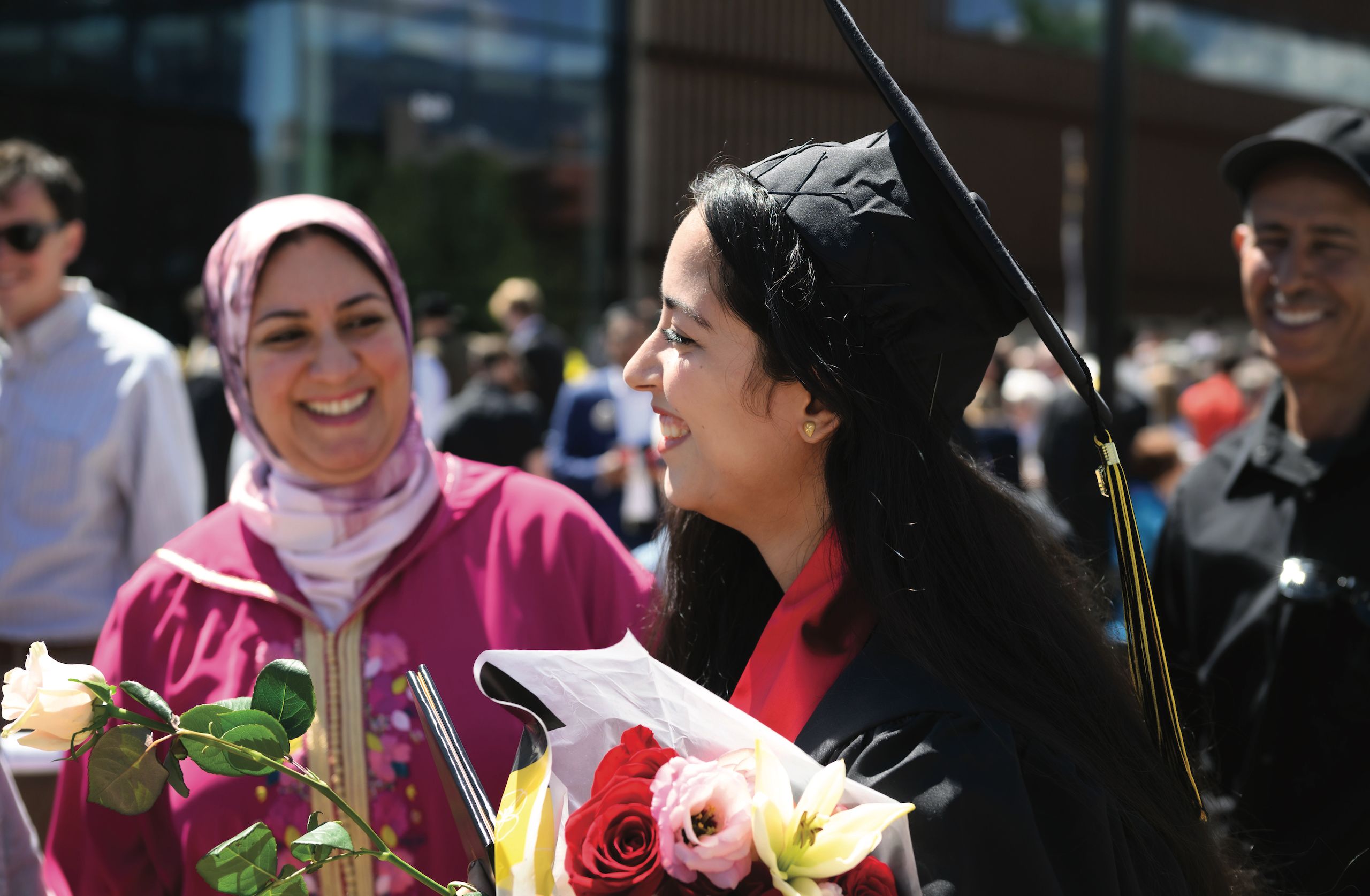 Student celebrating with family members after graduation at Ed Robson Arena