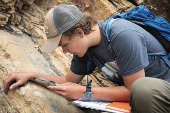 Drew Shippey ’21 calculates the direction of a rock formation. Visiting professor Tim Gibson led his Geology of the Pikes Peak Region class on a hike through Wide Eagle Trail in Cañon City to investigate rock types and learn the skill of measuring hits and strikes for rock formation.